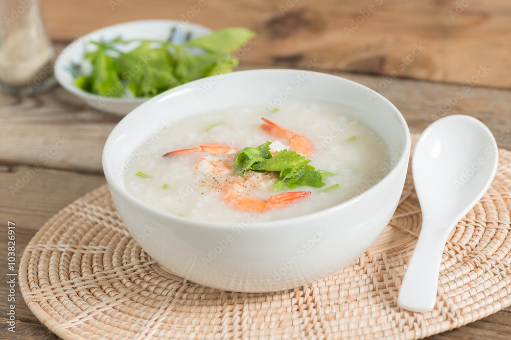 Rice porridge with shrimp in white bowl.