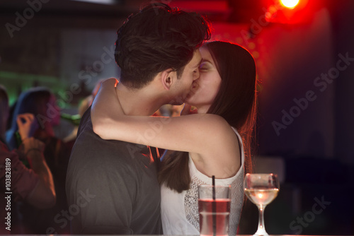Couple kissing at bar