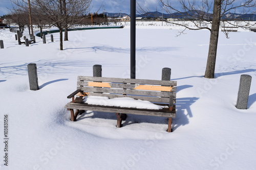 雪の中のベンチ／降雪後の公園で、ベンチを撮影した冬イメージの写真です。
