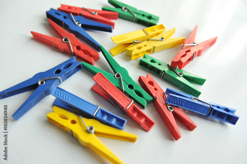 Multi-coloured clothespins on the white background Multi-coloured clothespins on the white background