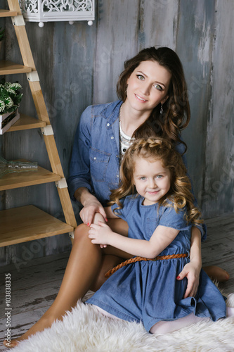Happy family mother and little daughter hug and spending time together dressed in jeans dress