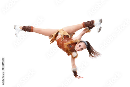 Young professional cheerleader dressed in a warrior costume standing on one hand. Horizontal splits photo