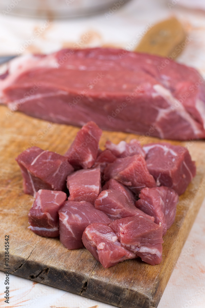 Beef steak cut into cubes. Red meat on the cutting board