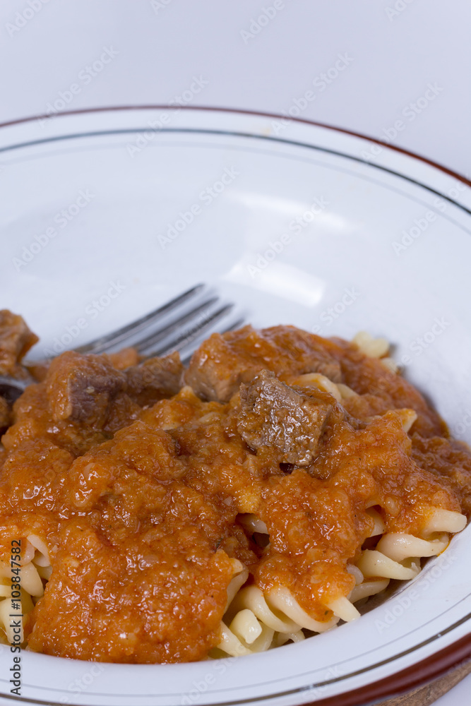 Served beef stew with macaroni in the metal plate
