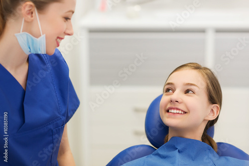 happy female dentist with patient girl at clinic