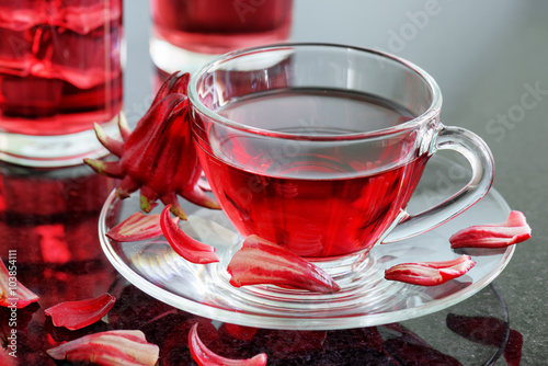 Cup of hibiscus tea (rosella, karkade, red sorrel) on table