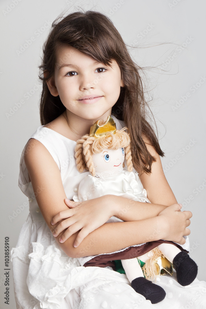 Adorable little girl cuddles and plays with her doll Adorable little girl cuddles and plays with her doll