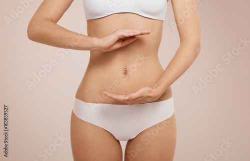 Woman showing sign bio balance on her stomach isolated