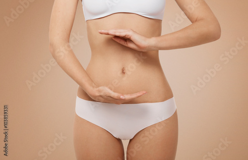 Woman showing sign bio balance on her stomach isolated