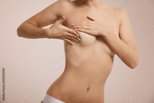 Breast cancer concept - woman checking her breast.