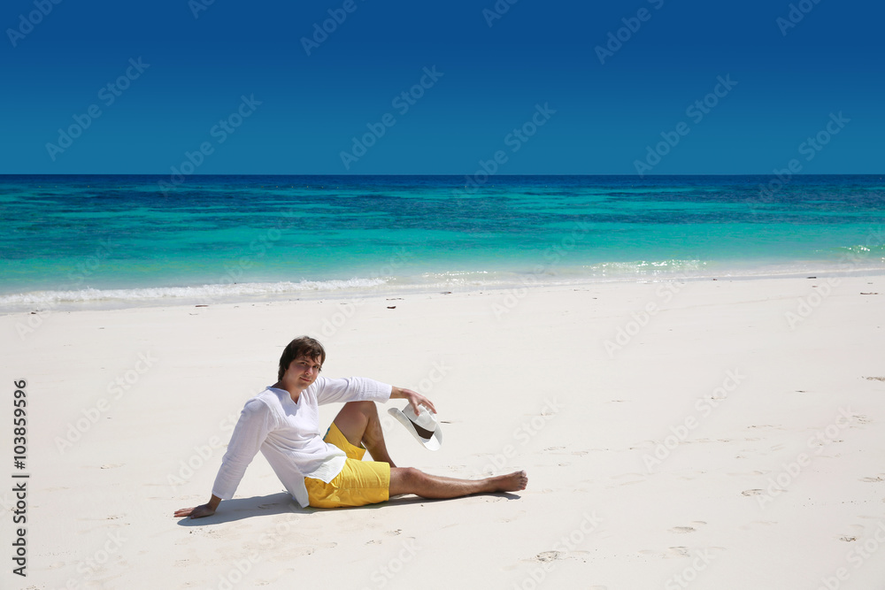 Summer. Relax. Successful handsome man resting on exotic beach w Summer. Relax. Successful handsome man resting on exotic beach w