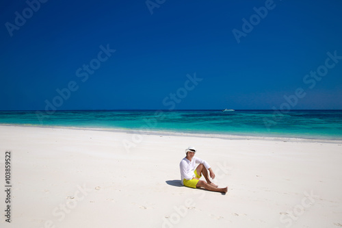Summer beach. Relax. Successful handsome man in hat resting on e