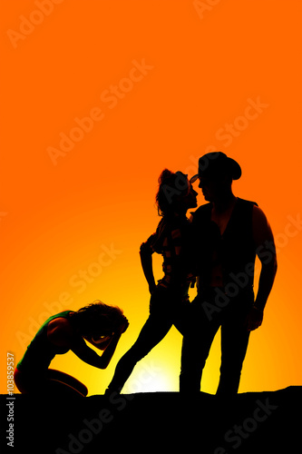silhouette of woman kneeling hands on head in the sunset near a