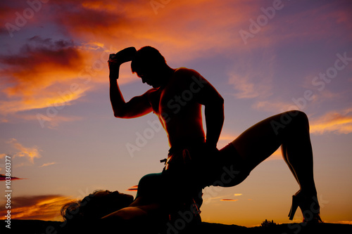 Fotografi silhouette of woman in the sunset laying back with butt and knee
