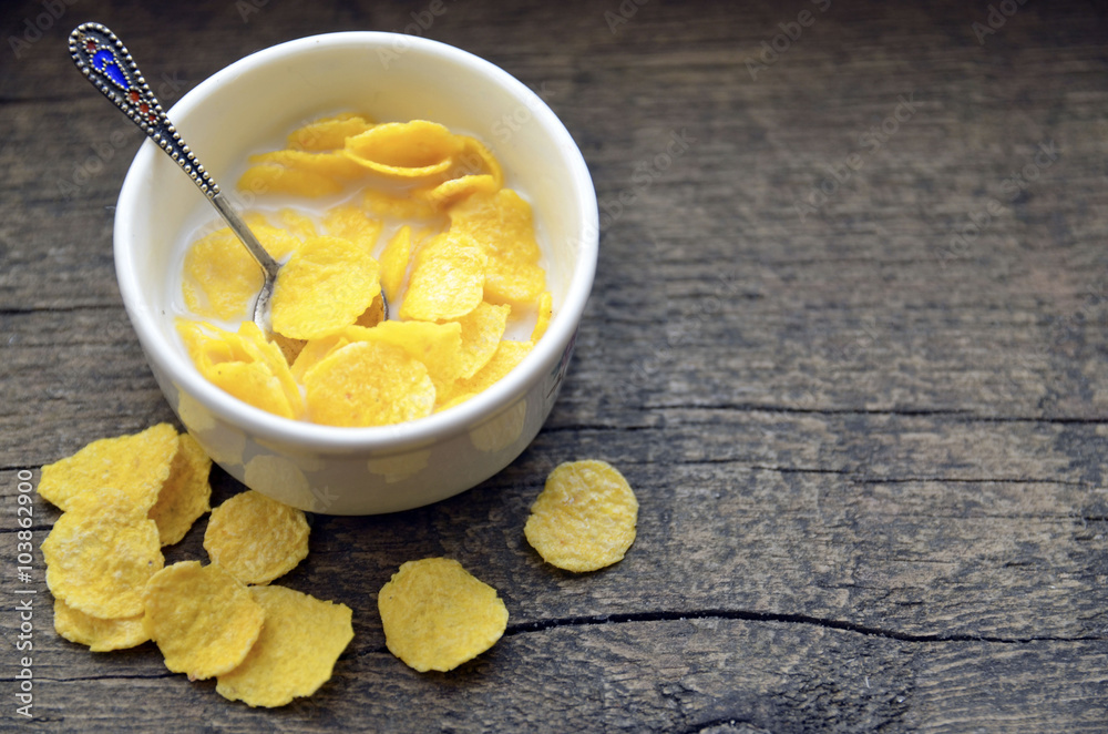 Corn flakes with milk in white bowl on old wooden background. Healthy breakfast. Corn flakes with milk in white bowl on old wooden background. Healthy breakfast.