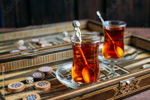Fotografiet Turkish sweets and tea on the backgammon Board