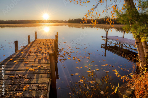Фотография Autumn sunrise over dock on Moose lake in northern Wisconsin.