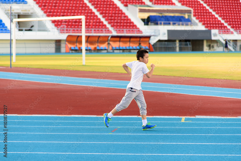 Fototapeta premium Boy runnin on blue track
