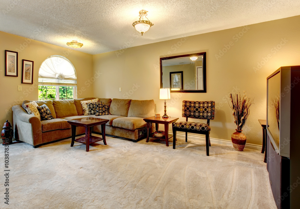 Fototapeta premium Living room with rounded window and sectional couch.