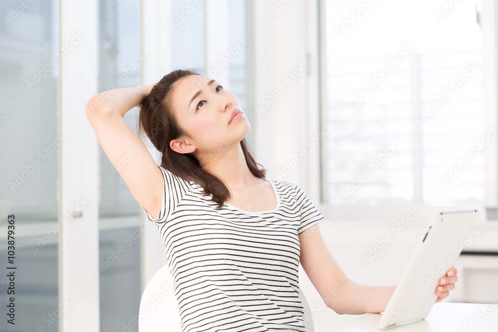 部屋でタブレットを見る女性 考える 部屋でタブレットを見る女性 考える