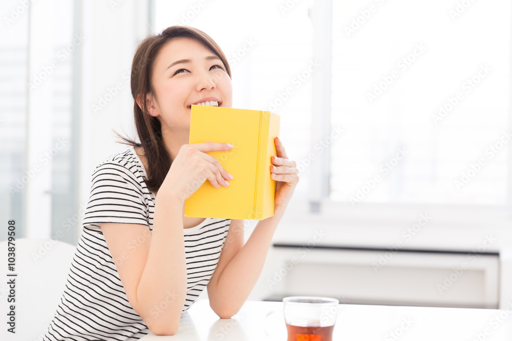 部屋で本を読む女性