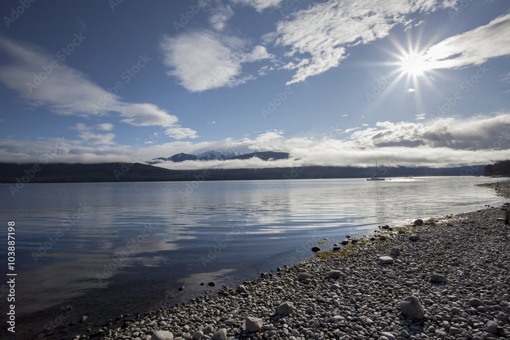sun light over lake te anau fiordland national park new zealand