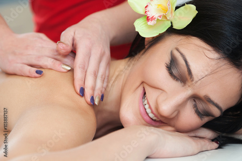 Smiling woman relaxing during back massage at spa