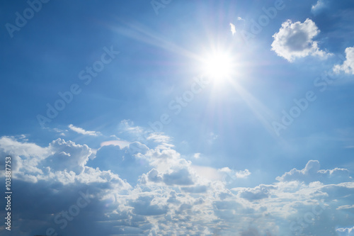 Rays of the sun in the blue sky and white clouds