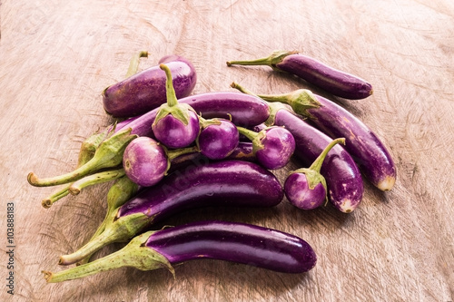 Round and long fresh organic raw purple brinjal or eggplant or aubergine. Healthy and delicious purple eggplants on wood table. (Selective focus). photo