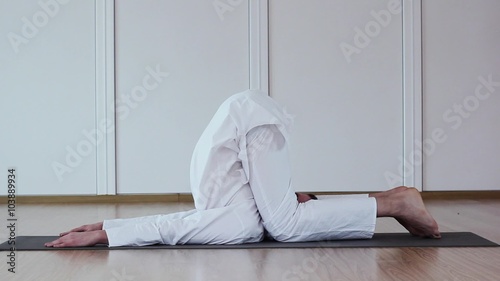 Handsome Man Doing Yoga.Karnapidasana photo