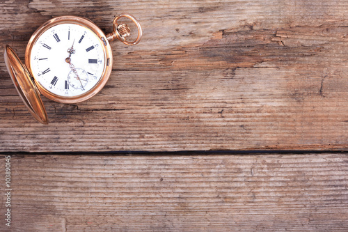 background of golden pocket watch on wooden surface