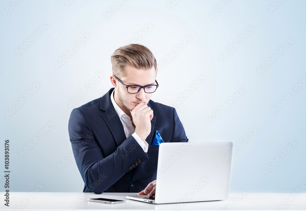business man, with a serious face working for laptop business man, with a serious face working for laptop