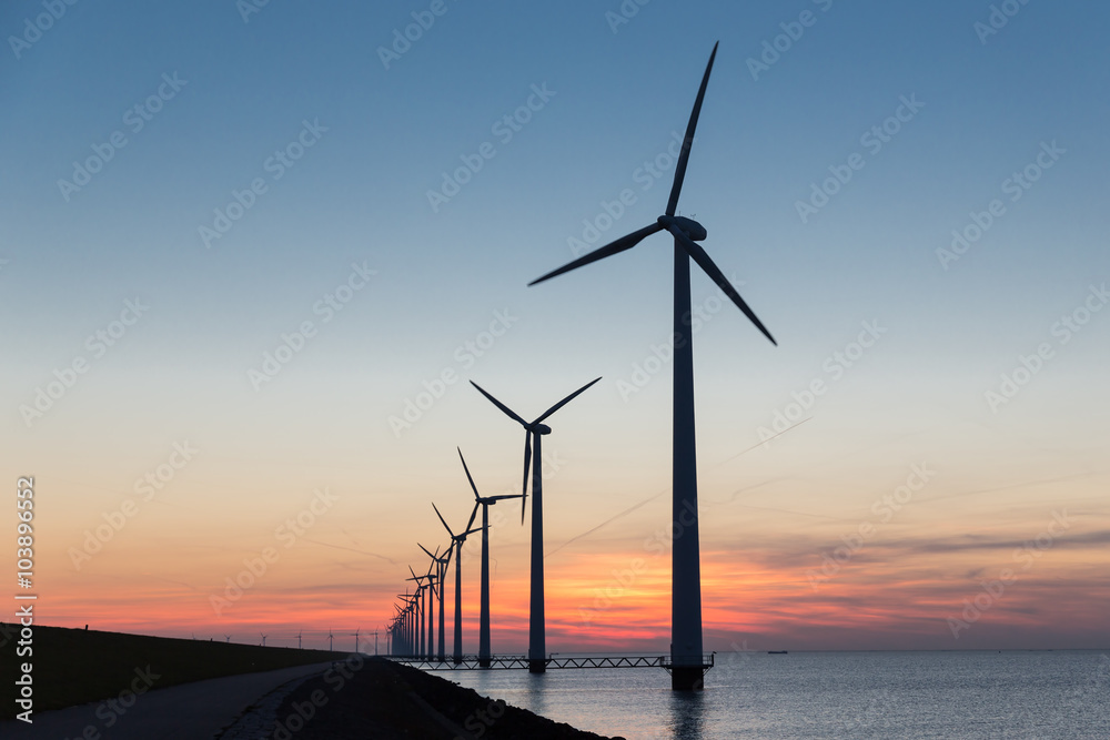 Dutch row offshore wind turbines at beautiful sunset