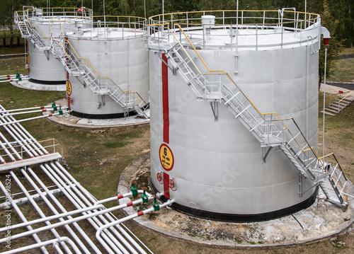 old large oil storage tanks with pipes and valves