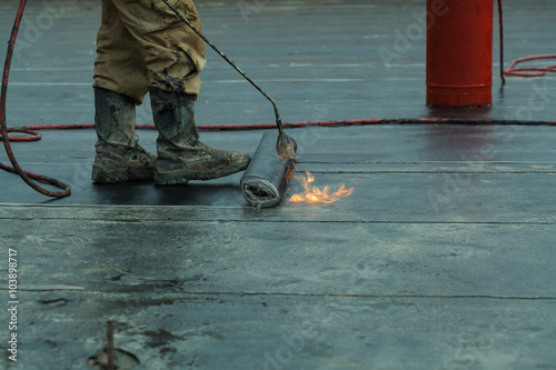 Obraz na plátne Installation of roll roofing waterproofing propane blowtorch during construction