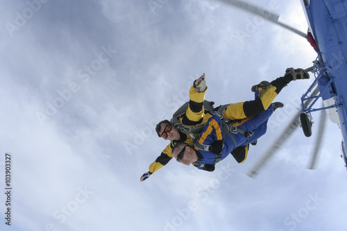 Tandem jump in the sky with clouds.