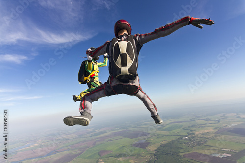 Girl and guy skydivers in freefall in the clouds.