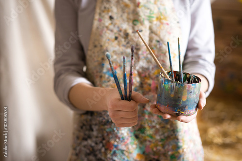 Closeup of female artist hand holding paintbrush photo