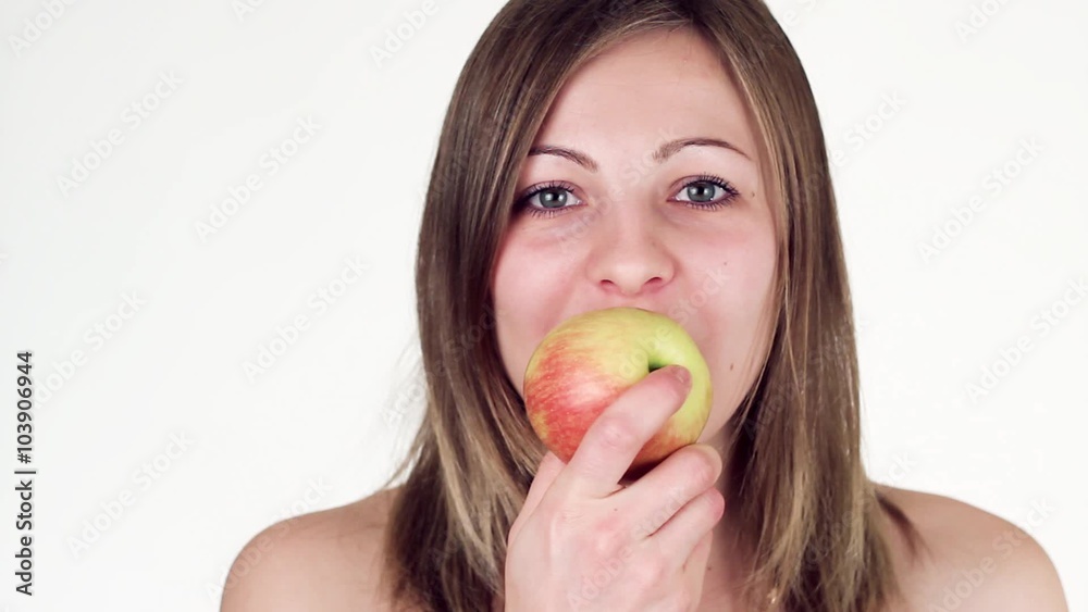 Beautiful girl eats an apple and looking at the camera. Beautiful girl eats an apple and looking at the camera.