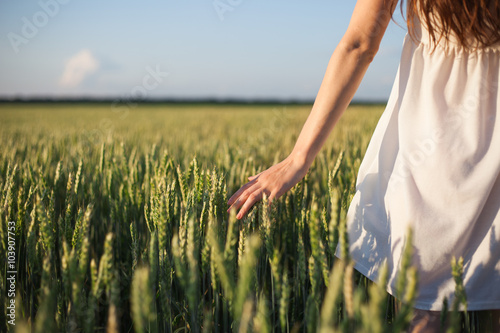 Girl touching wheat.