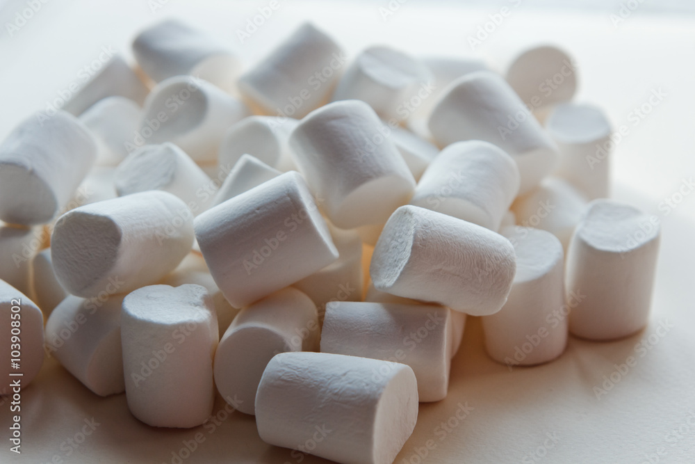 beautiful little marshmallows scattered on a light background beautiful little marshmallows scattered on a light background