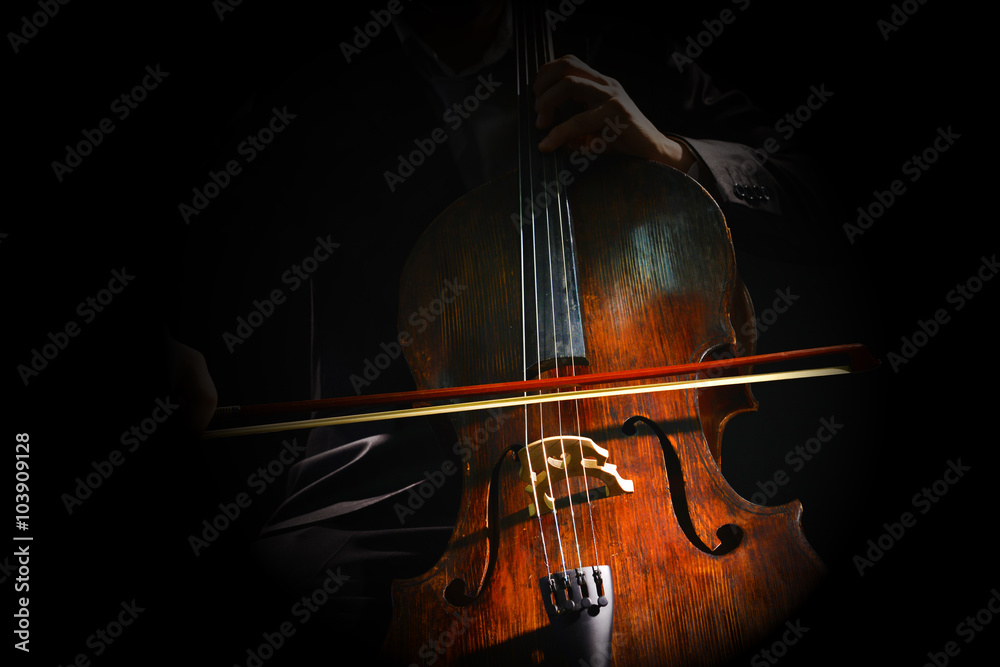 Naklejka premium Man playing on cello on dark background