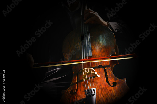 Print op canvas Man playing on cello on dark background