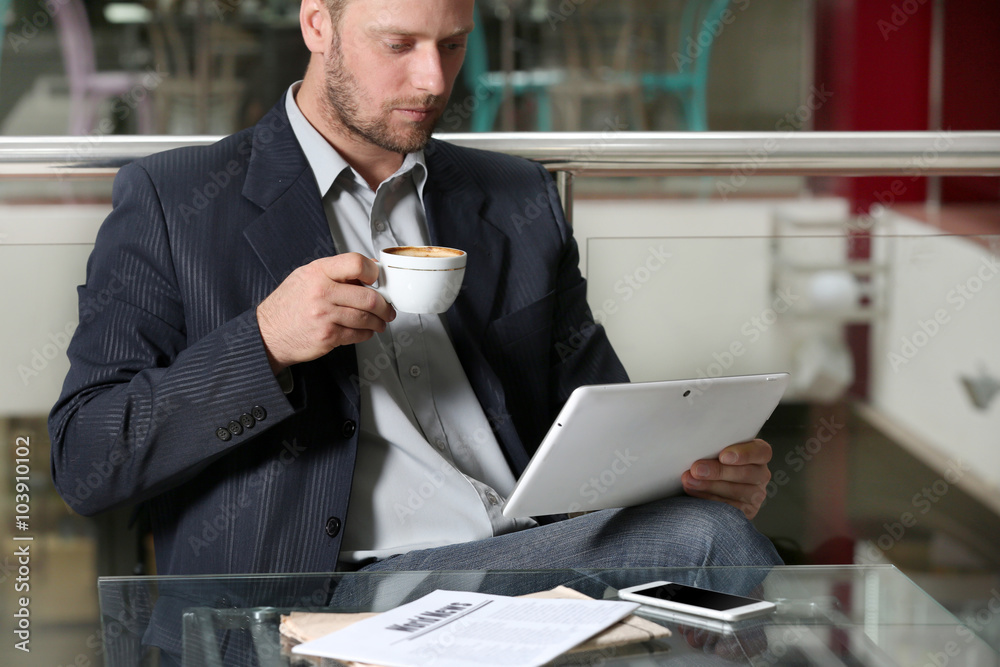 Young attractive businessman having lunch and working in a cafe Young attractive businessman having lunch and working in a cafe