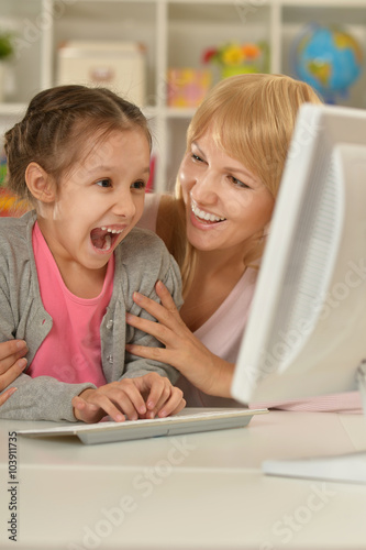 girl playing with mother on computer