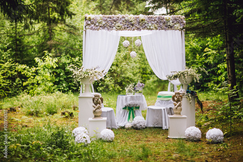 Obraz na płótnie Wedding arch with table and chairs decorated with flowers w salonie