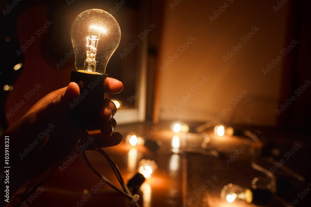 Incandescent light bulb warm turned on. Garland of tungsten lamps