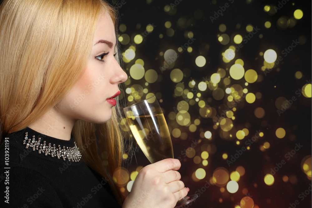 cheerful girl with a glass of champagne on the background of bright lights cheerful girl with a glass of champagne on the background of bright lights