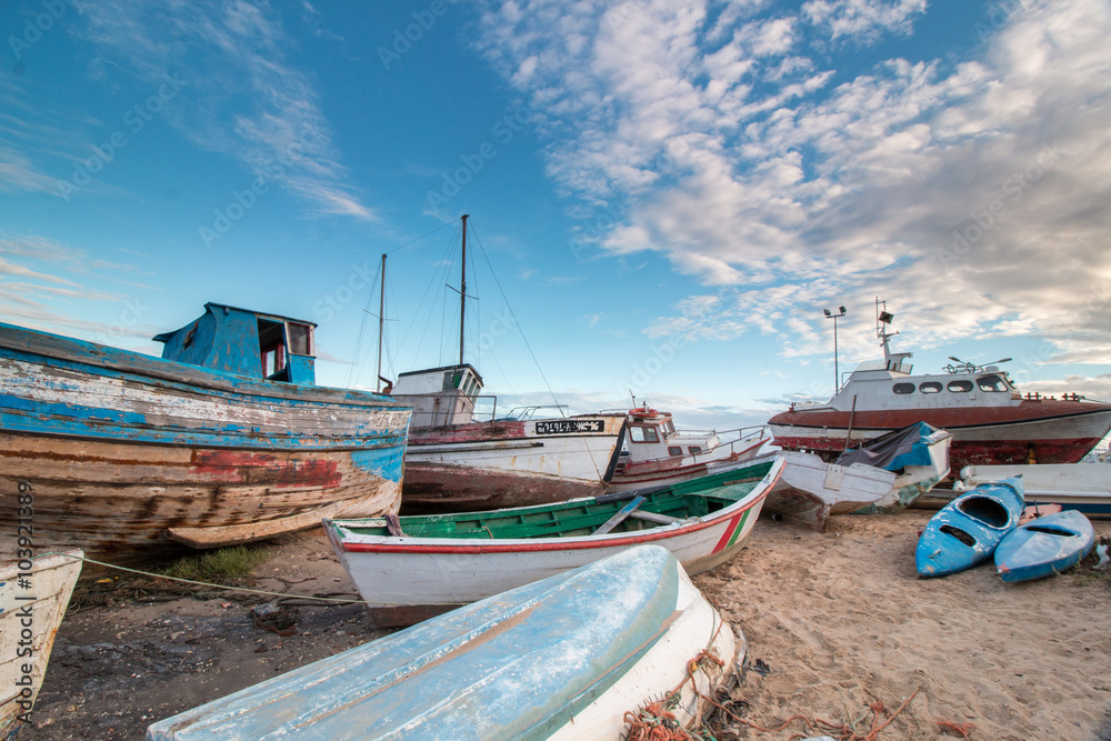 View of many traditional fishing boats anchored on low tide near Santa Luzia village, Portugal.