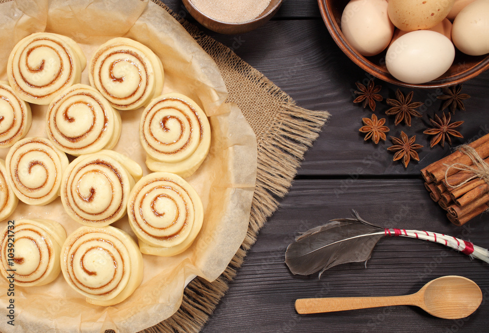 Raw cinnamon rolls prepared for roasting next to eggs and kitche Raw cinnamon rolls prepared for roasting next to eggs and kitche